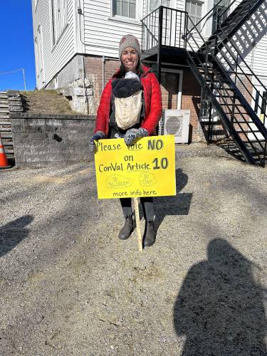 Maureen Troy holds a sign against the ConVal reconfiguration in Hancock.