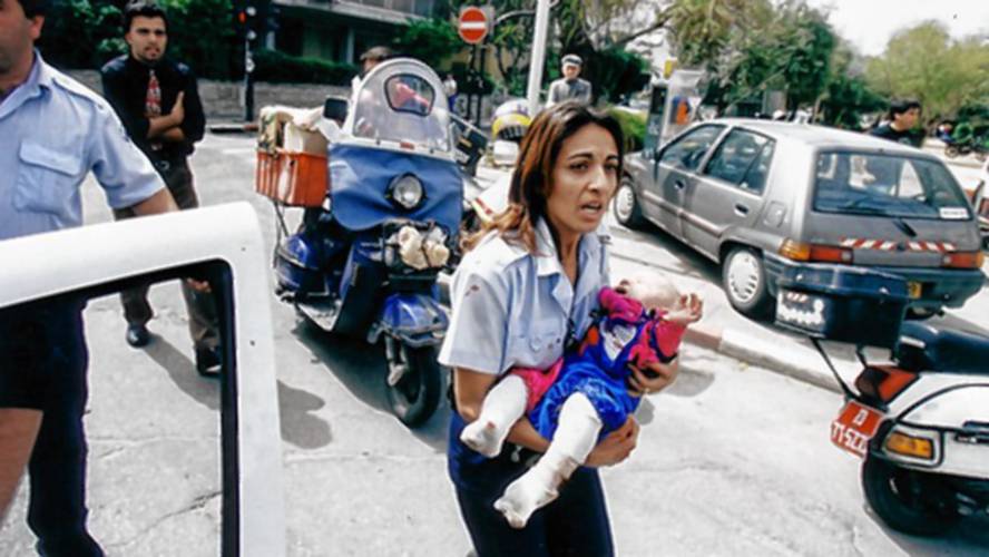 Policewoman Ziona Busheri carries six-month-old Shani Winter after Shani’s mother, Anat Rosen-Winter, was murdered by a suicide bomber at Tel Aviv’s Café Apropos in  1997.