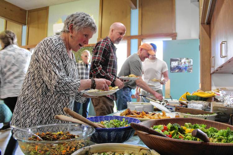 Potluck attendees select dishes.
