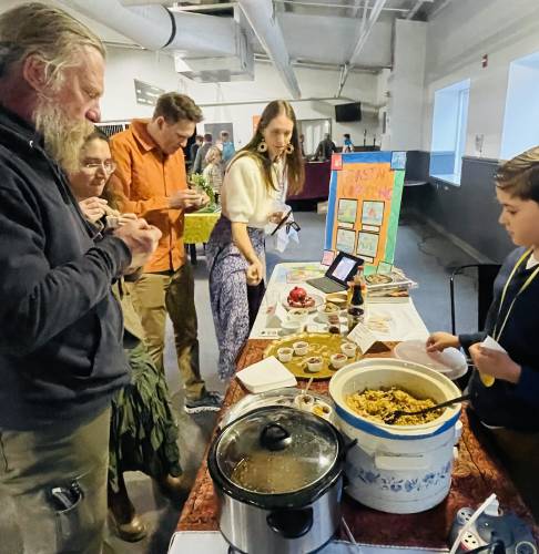 Fifth-grader Enoch Ashfar, right, dishes out samples of Persian cooking to (from left) Phil Petrov, Anna Petrova, Jace McLean and Jill McLean.