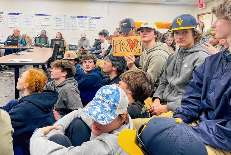 ConVal students Garret Rousseau (displaying sign) and Eliot Dumas (in CV cap) were some of the more than 100 supporters who turned out in support of ConVal Athletic Director Kevin Proctor. 