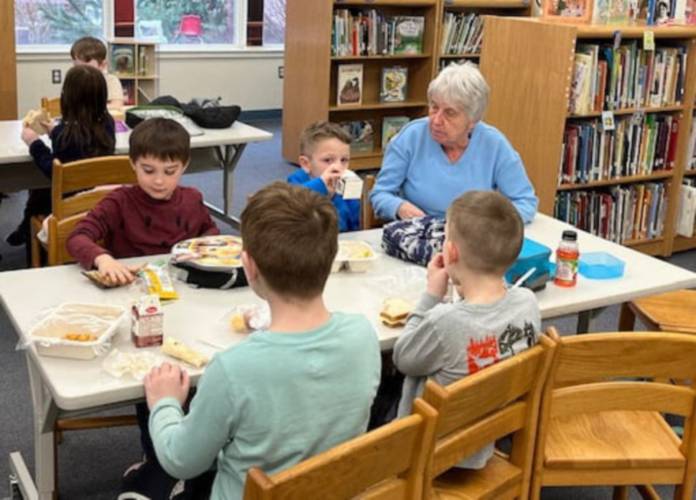 Antrim Elementary School students sit with a Lions Club member during the Lunches with Lions program. 