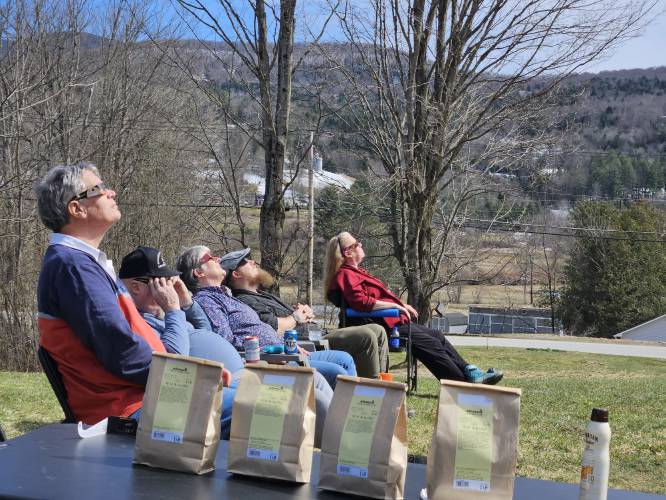Mark Nichols of Dublin, John Black, Mary Black and Sam Black of Stowe, Vt., and Tracy Lambert of Stowe watch the eclipse.
