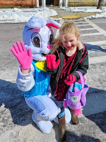 Salem Landry waves with the Easter Bunny, each sporting a matching pink glove.