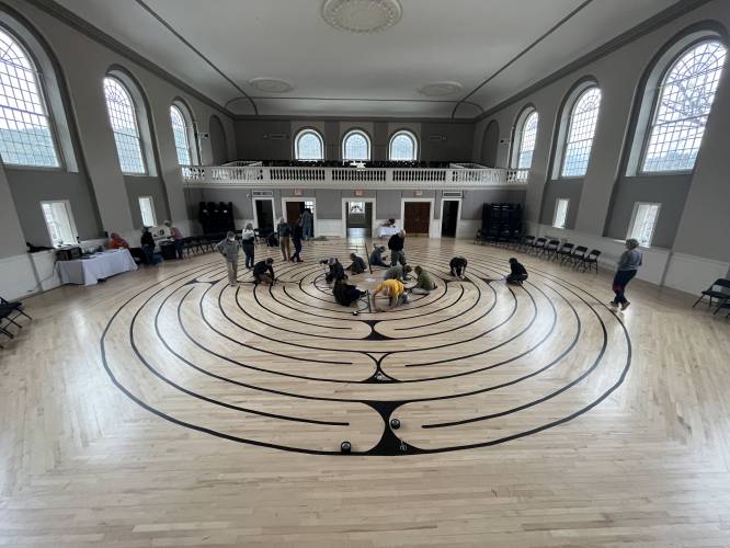 Volunteers tape the labyrinth in the Peterborough Town House.