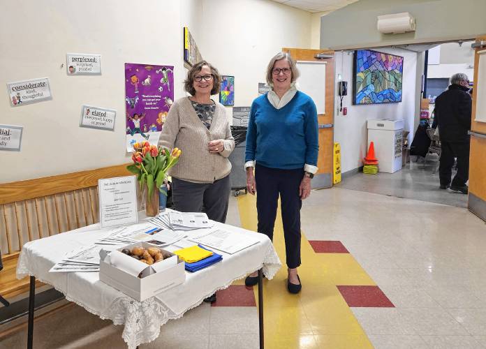 Julie Rizzo and Mary Loftis greet Dublin Town Meeting attendees with doughnuts.