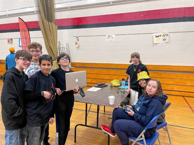 From left, Ian Wood, Quinn Lake, Dylan LaRouche and Bradley Allen of the Great Brook aerial drones team consult with Mallory Mason, Della Sutherland and Gwen Moritiz of the Awesome Potatoes robotics team. 