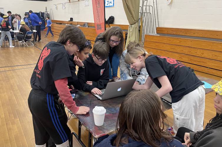 Members of the Great Brook Aerial Drones Team and the Awesome Potatoes confer on code for an upcoming round. 