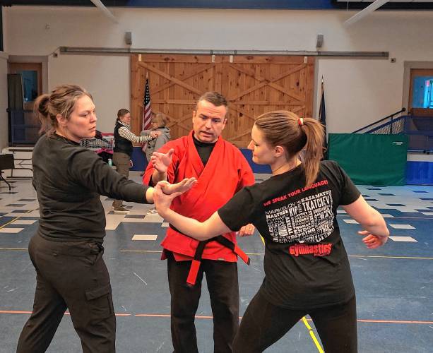 Instructor John Stewart guides attendees through a defense technique for escaping an attacker’s arm grab.