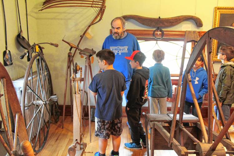  LEFT: Jakob Chin examines artifacts from the 1800s during a tour of the Wilton Historical Society Museum.