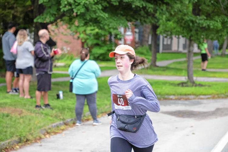 Marga Hutchenson of Weston, Mass., crosses the finish line in Saturday’s Run for the Honey. 
