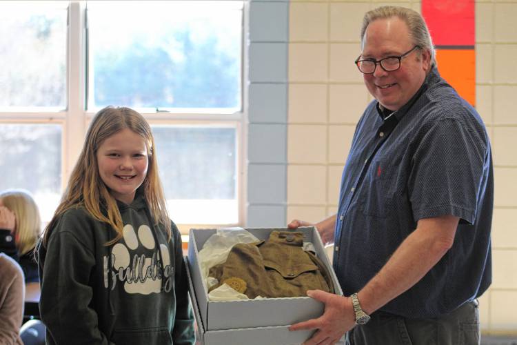 Scott Kraska, owner of the New Ipswich Museum of History, gifts a World War I uniform to 12-year-old Boynton Middle School student Brooke Sallila, as the first prize in the museum’s “Why is History Important?” essay contest.