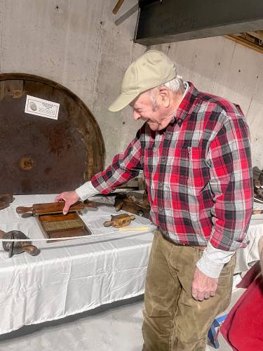 Francestown Heritage Museum curator Bill McAuley demonstrating an antique apothecary pill-crusher. 