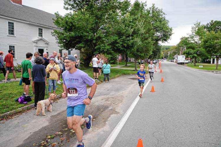 Mark Wilson of Harrisville crosses the finish line, closely followed by 9-year-old Wesley Fab.