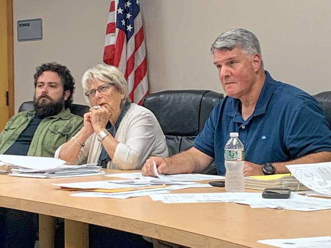 Zoning Board member Ross Thermos, Vice Chair Marcia Breckenridge and Chair George Charmichael discuss a request for a variance to allow a planned unit residential development on a property that is partially in a business district.