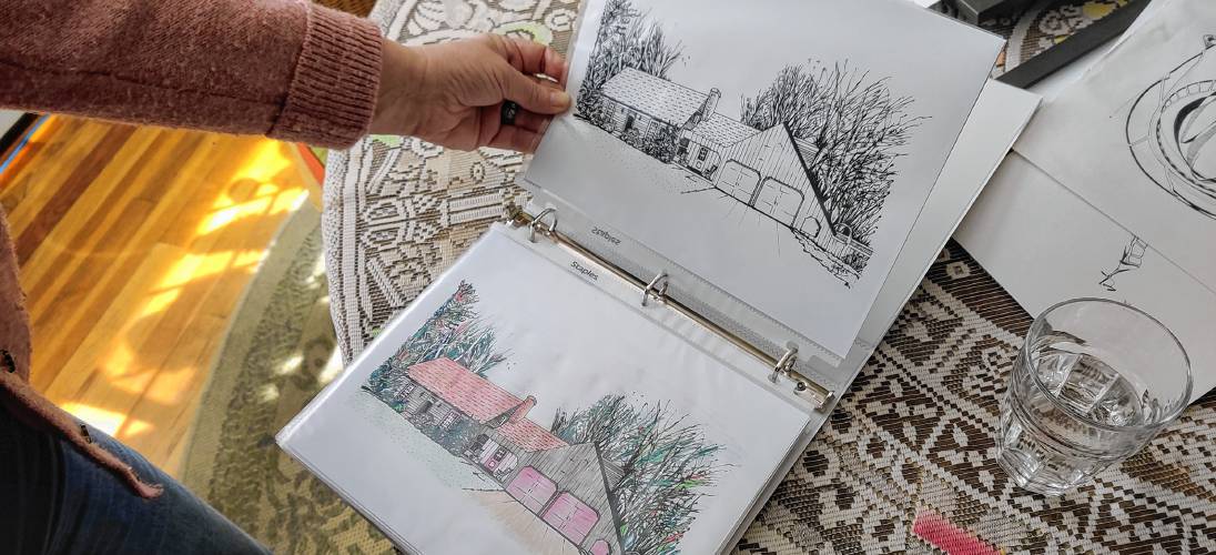 Deb Caplan displays black-and-white and hand-colored prints of her line artwork.