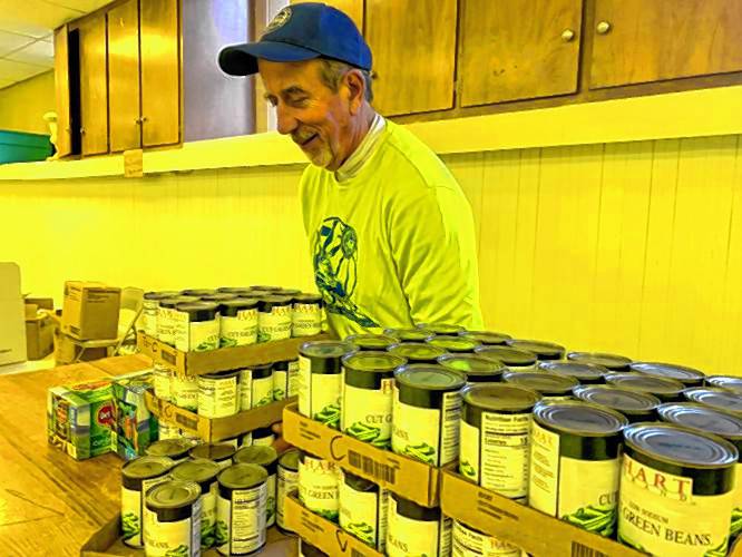 St. Vincent de Paul Food Pantry President Kevin Little helps pack side dishes into Thanksgiving baskets for the pantry’s Thanksgiving dinners last year. The pantry will sponsor a Poor Man’s Supper Saturday at Sacred Heart Church in Greenville.