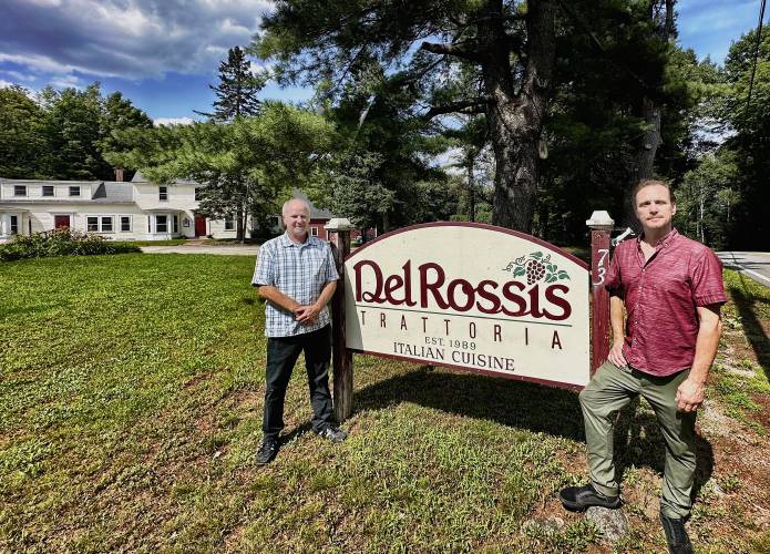Bill O’Mahony (left) and Wayne Asbury pose in front of the sign outside Del Rossi’s as they begin their first week as the new owners.