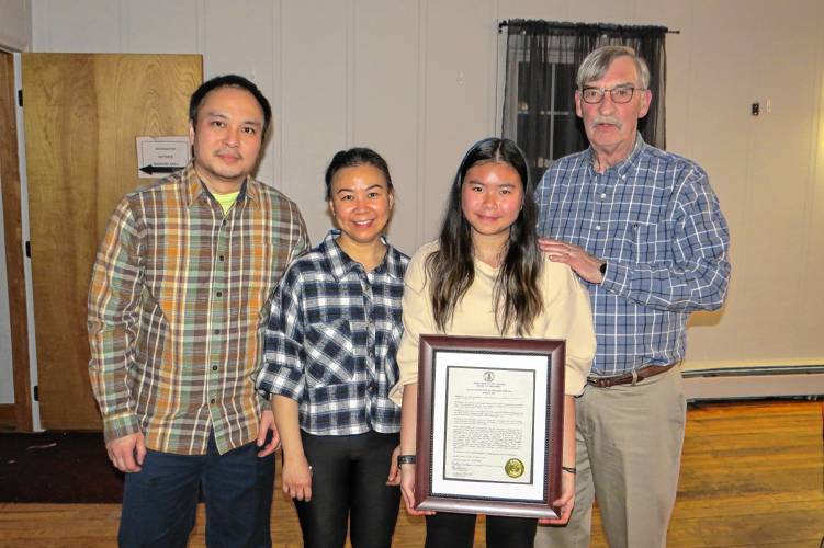 Select Board Chair Frank Sterling, right, presents the Youth Volunteer of the Year award to Jessica Yap and her parents.