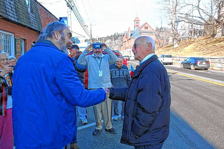 Select Board member Kermit Williams and Elmer Santerre shake hands after Williams read a official commendation and declaration from the State of New Hampshire during a ceremony last year honoring Santerre's retirement from Elmer’s Barbershop.