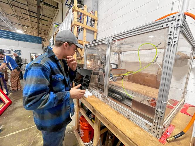 Jacob Wyatt examines the CNC machine used to engineer parts at MAXT Makerspace. 