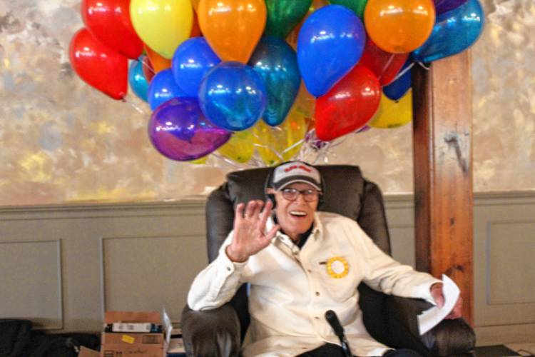 Don Lawler sits in a place of honor with 100 balloons, each with a $1 bill inside as a birthday present from his family.