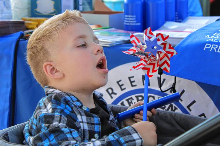 LEFT: Julien Morton, 3, of Jaffrey, blows into a pinwheel given out at the Greenville Emergency Management table.