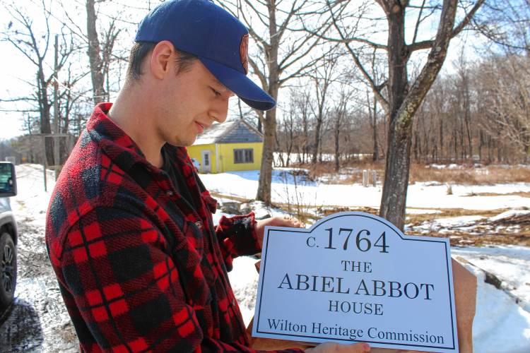 Samuel Cochrane accepts a new sign for his house built in 1764 on Saturday.