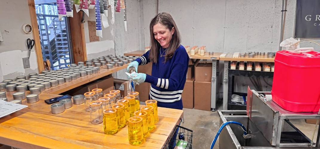 Leyna Cannon of Grey Horse Candle Company fills a batch of jars with soy-based wax.