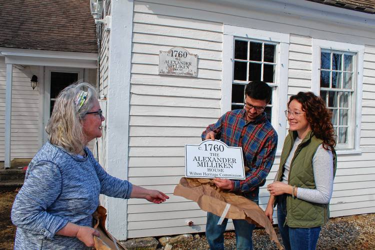 Heritage Commission co-Chair Deb Mortvedt presents Allison Coneys and Caleb Mattson with a new sign for their historic home on 555 Abbot Hill Road.