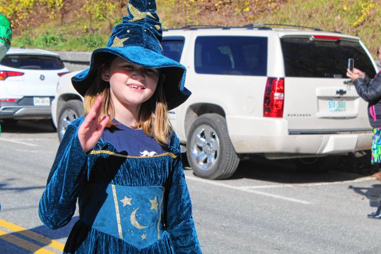 Fifth-grader Isabella Green, dressed as a wizard, waves as she marches down Main Street.
