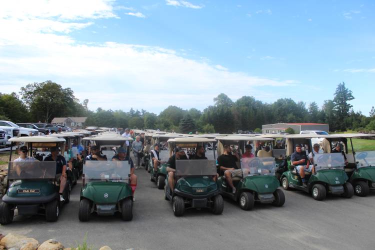 Teams ready for the tournament start in their golf carts.