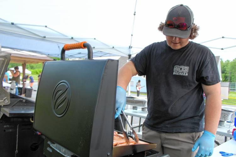 Sethe Talbot of New Ipswich cooks hot dogs for a fundraiser to assist former Greenville resident Aiden Foss, who was injured in a crash, during the Greenville Independence Day celebrations July 3 at Memorial Field.