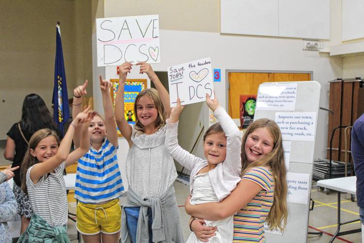 Isla Higley, Annika Jackson, Emma Garnham, Cora Higley and Mila Boutelle hold up signs in support of Dublin Consolidated School during a forum on Wednesday.