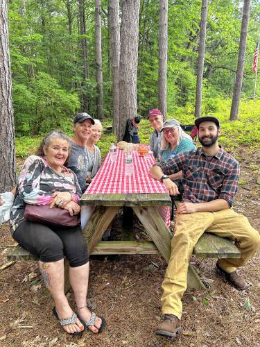 Irene L’HommeDieu, Mike Williamson, Margie Williamson, Rich Dufresne, Karen Shea Dufresne and Will Cote gather around a picnic table.