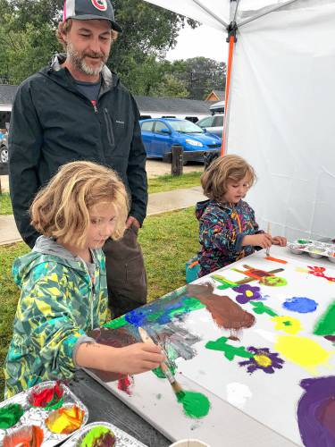 Eva and Annabelle Berry, with their father Justin Berry, paint during the Children’s Market.