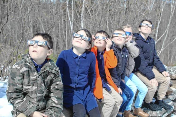 Avery French of Rindge, left, Adelaide Brown of Fitzwilliam, Emmett French of Rindge, Carson Desmarais of Rindge, Elaina Desmarais of Rindge and Asher French of Rindge view the eclipse from the Cathedral of the Pines in Rindge.