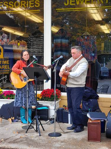Larry Gilbert and Suzanne McGettigan play outside Anytime Apparel on Saturday. 