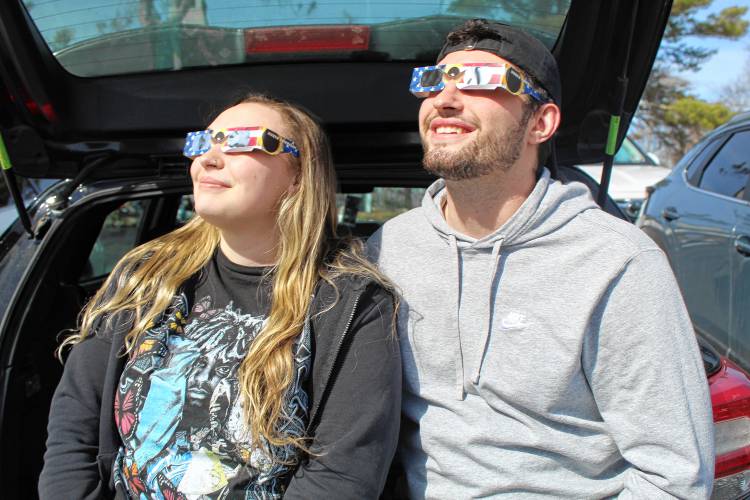 Kaliegh Driscoll and Nick Murach of Winchendon, Mass., view the solar eclipse from the back of their car at Cathedral of the Pines in Rindge.