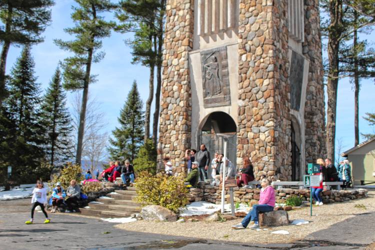 Spectators view the near-total solar eclipse from the Cathedral of the Pines in Rindge.