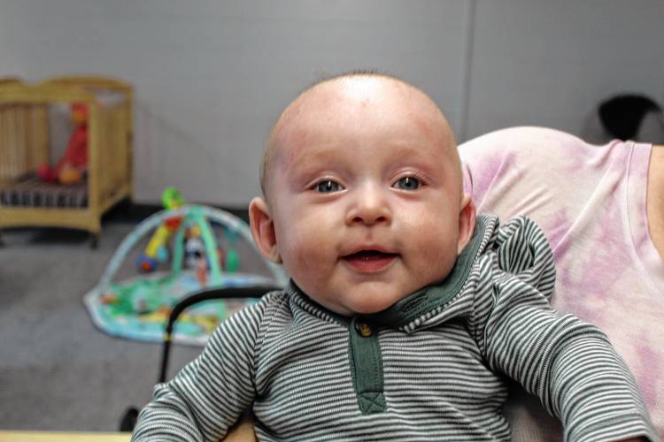 The youngest member of the Conant Middle High School daycare, Atlas Ahern, is cheerful after waking from a nap.