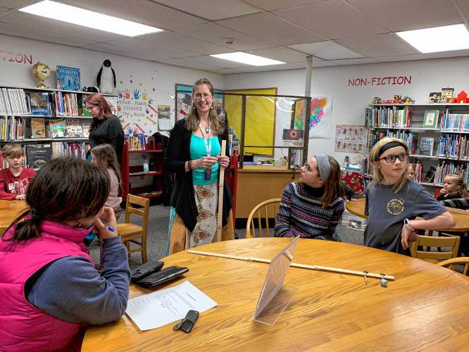 Eclipse ambassador Susan Rolke works with children at the Ingalls Memorial Library in Rindge to show the relative size and distance between the Earth’s moon and the sun.