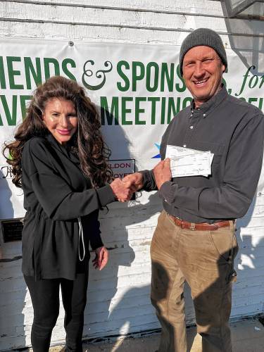 Sheldon Pennoyer, chair of the Friends of the Greenfield Community Meetinghouse, displays checks from NH Charitable Gaming with State Sen. Denise Ricciardi.