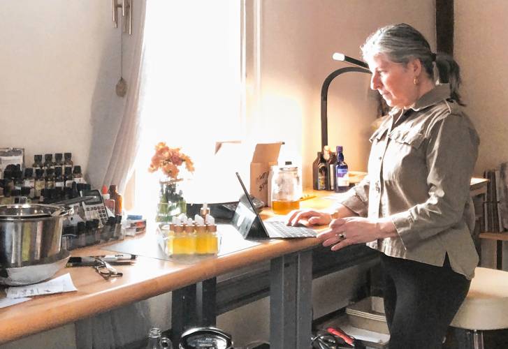 Entrepreneur Nanette Perrotte, surrounded by Lux Lifestyle self-care and bath products at her home office in Greenfield. 