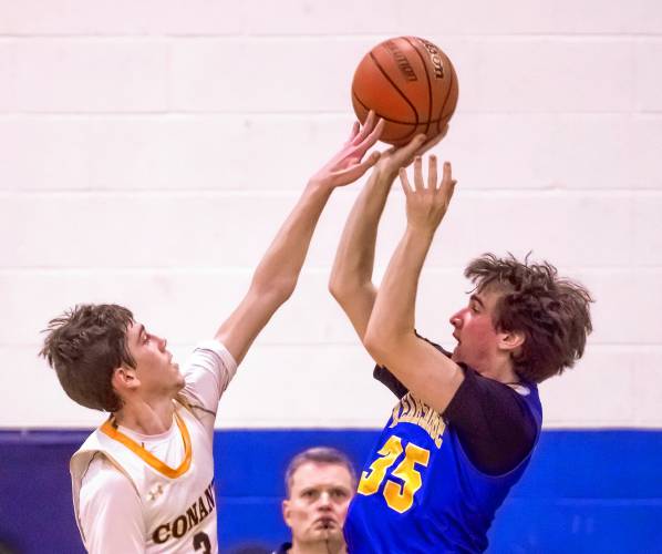Conant guard Manny Hodgson partially blocks the shot of  Kearsarge guard Eddie Kinzer at the buzzer to end the first half.