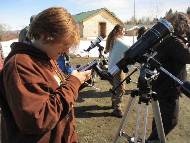 Dublin School student J. J. Johnson-Speaks prepares her solar telescope for viewing the partial eclipse.