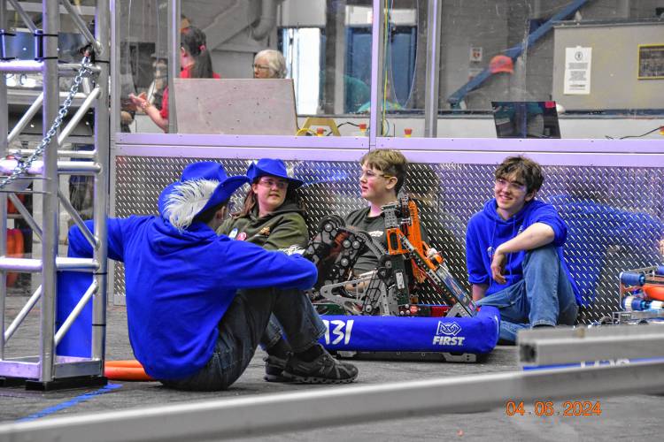 Jacob Wyatt in hat, from rear, and Kade Fletcher, right, waiting with members of Manchester’s FRC 4-H Team CHAOS between rounds at the FIRST Robotics district competition  in West Springfield, Mass.