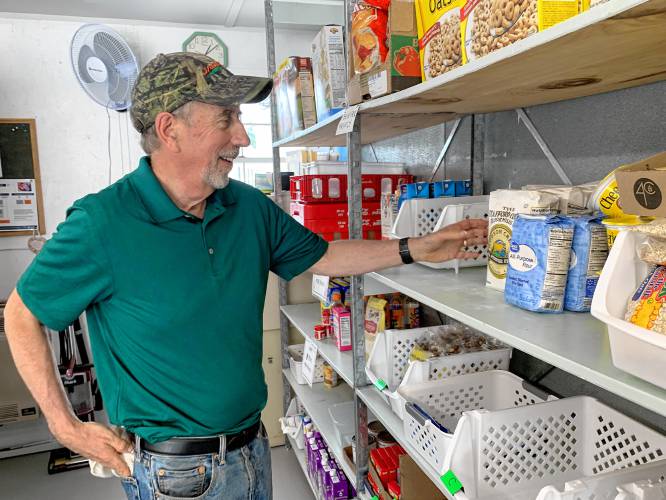 St. Vincent de Paul Food Pantry President Kevin Little stocks shelves at the food pantry after recent renovations.